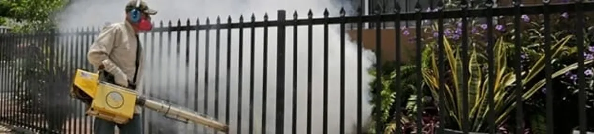 Mosquito control technician fogging a yard perimeter for mosquito reduction in Sarasota, FL